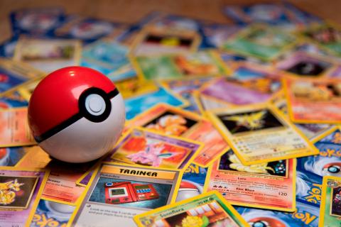 Image of a poke ball sitting on top of Pokemon cards